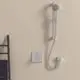 Thermostat von Ideal Standard an Wand montiert, mit Dusche und Brausekopf in einem modernen Badezimmer. Steuerungseinheit in der Nähe positioniert.